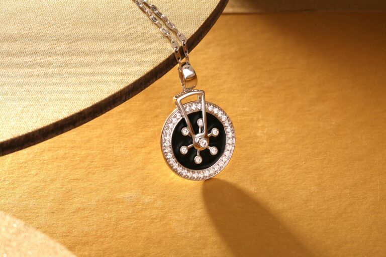 Close-up of a luxurious diamond and black pendant necklace on a gold background.