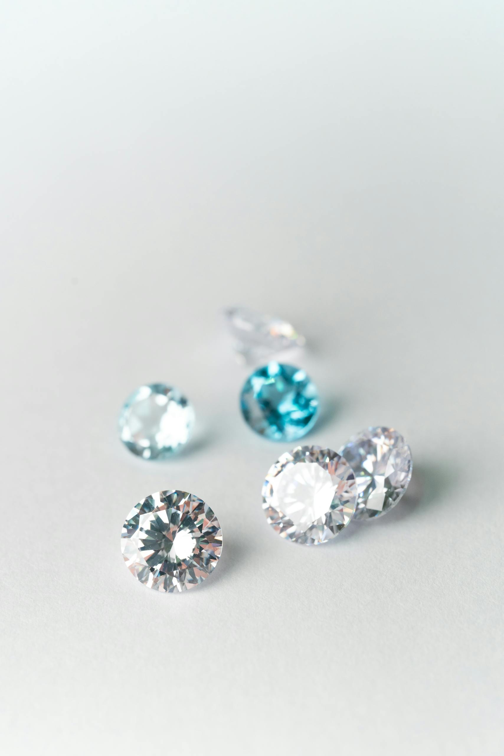 Close-up view of assorted sparkling gems on a white surface, showcasing brilliance.